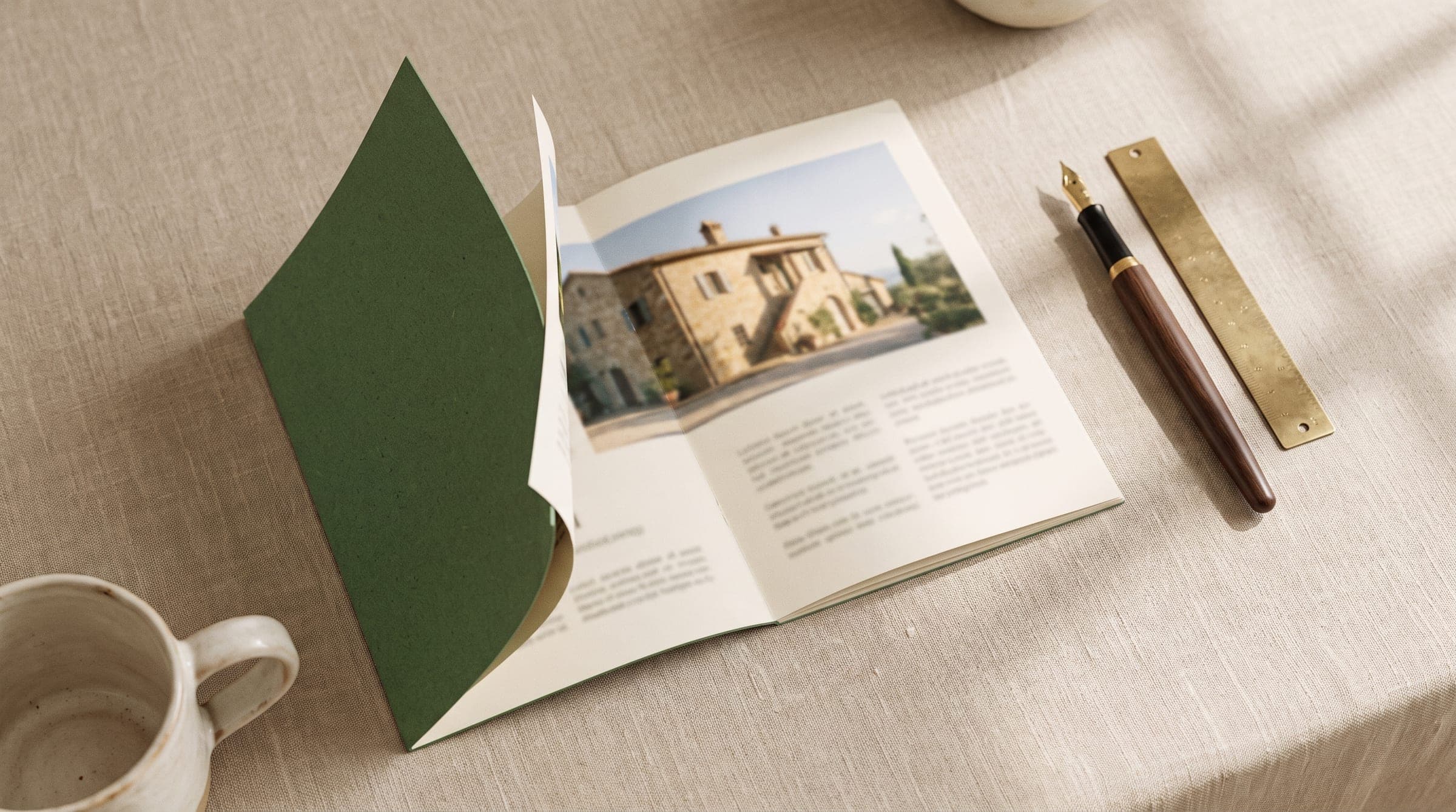 Printed Dubai buyer guide lying open on a warm beige table, showing an architectural photo spread