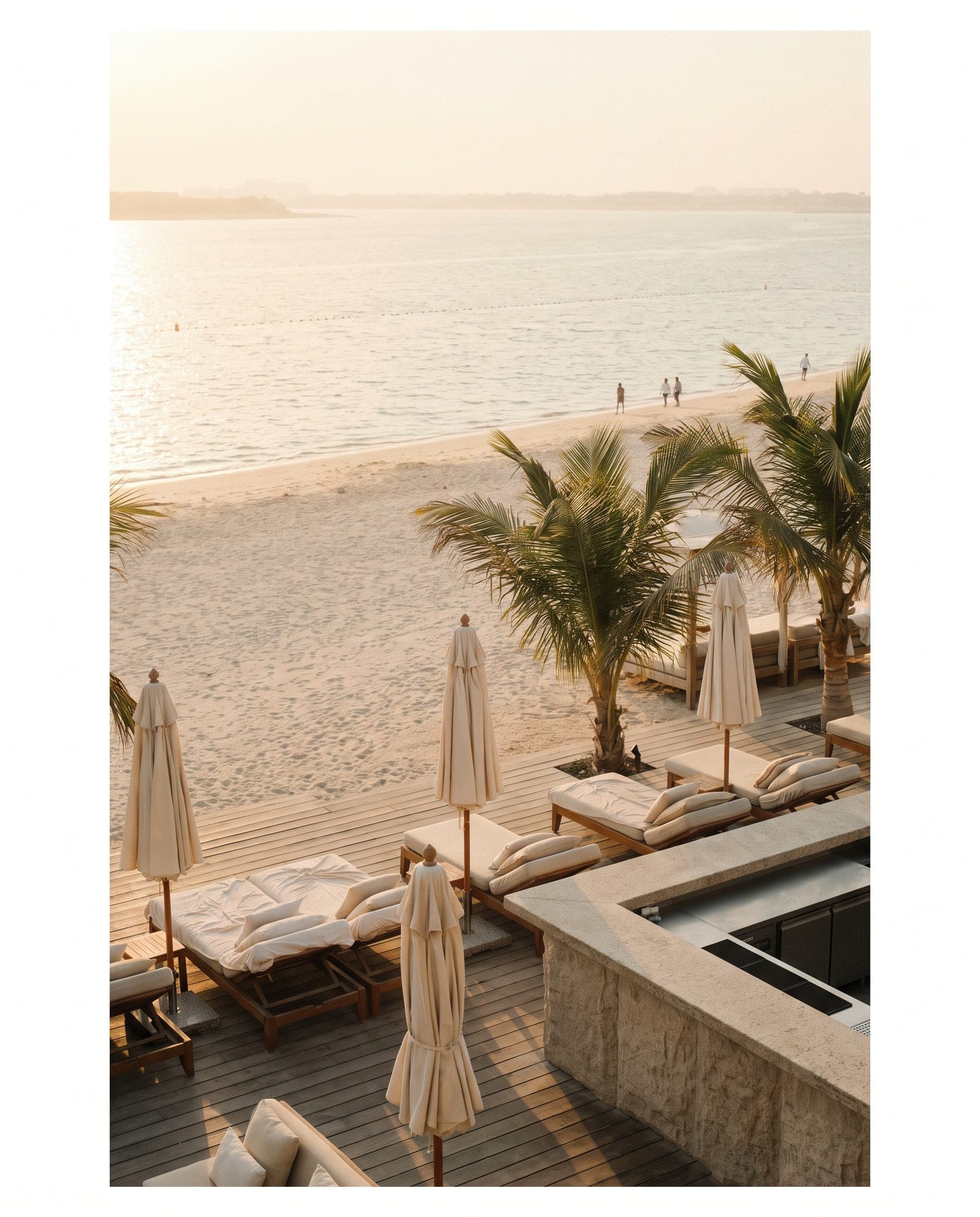 Palm Jumeirah beach club at golden hour with a timber deck, linen loungers and a calm sea